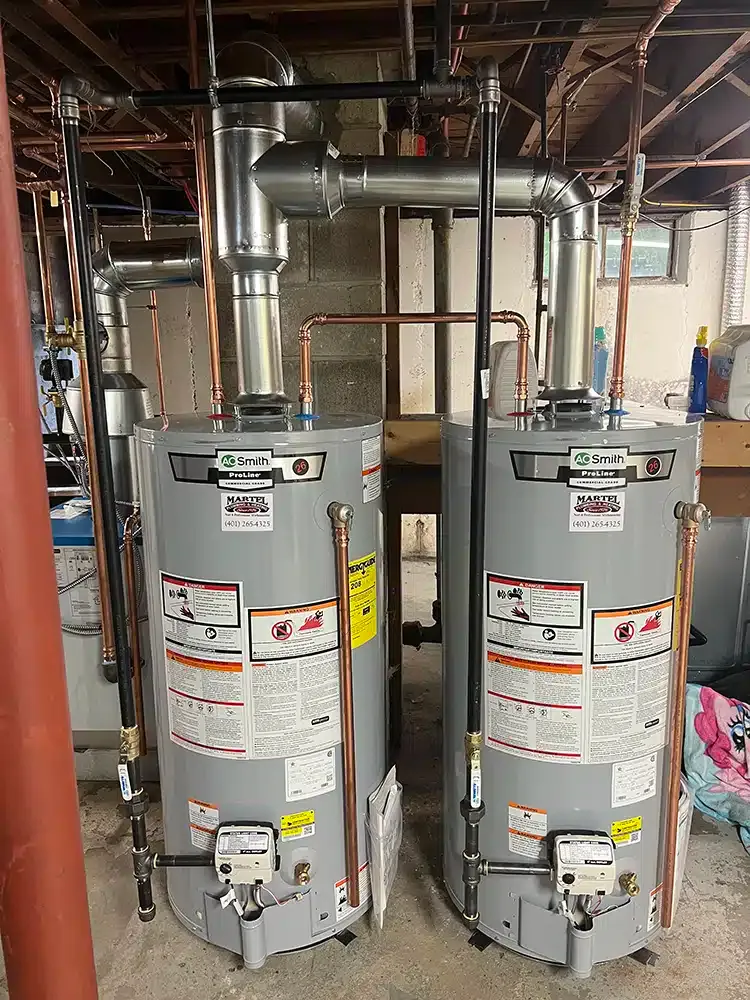 Two water heater tanks newly installed in a basement in Rhode Island.