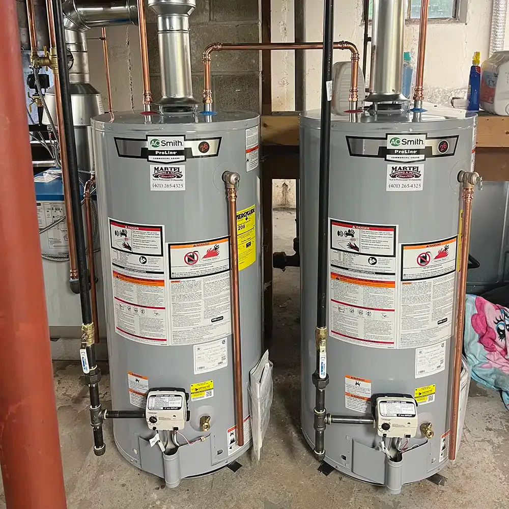 Two water heater tanks newly installed in a basement in Rhode Island.