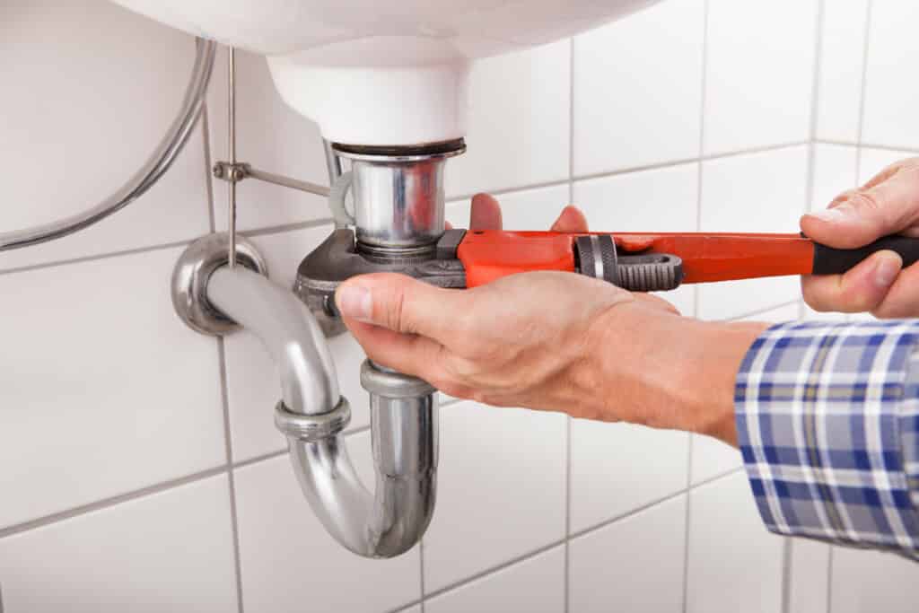 plumber repairing pipe leak